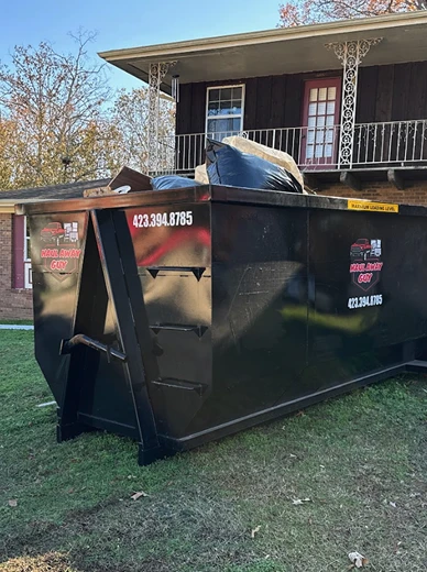 Large black dumpster near building