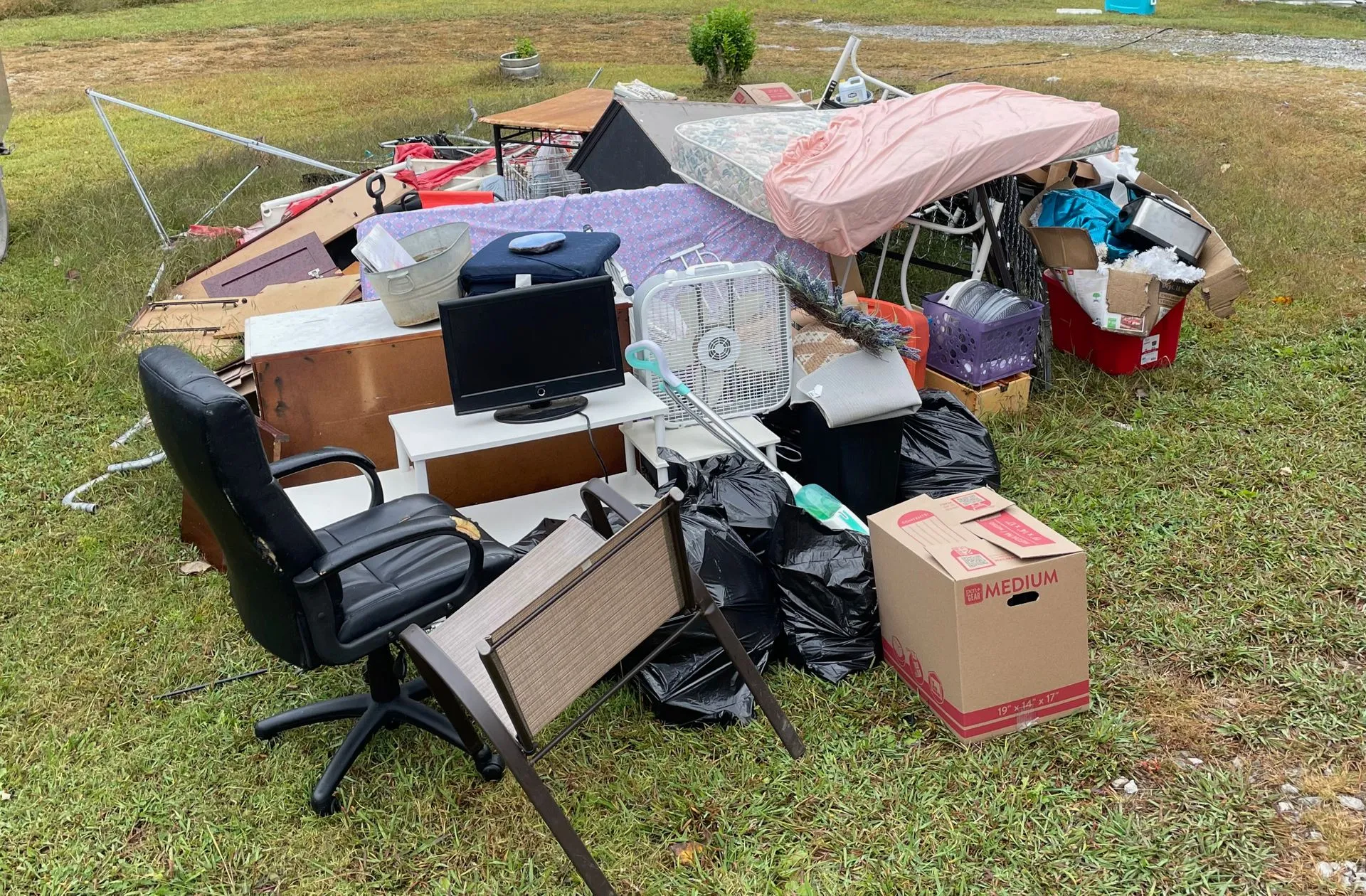Piled clutter in a grassy area.