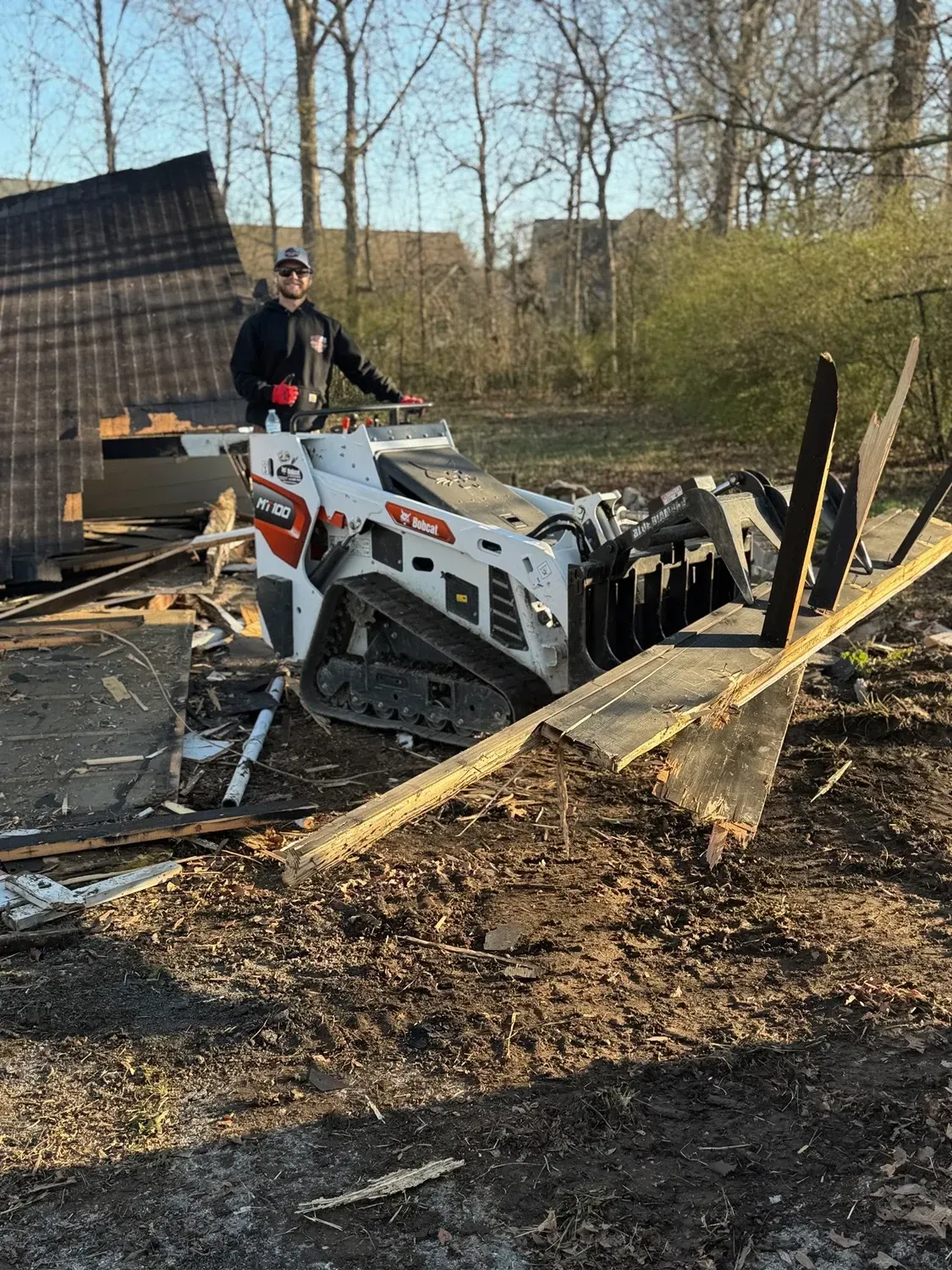 Person operating machinery in debris.