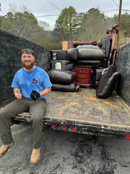 Man sitting in truck with furniture.
