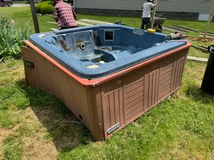 Hot tub being removed from yard
