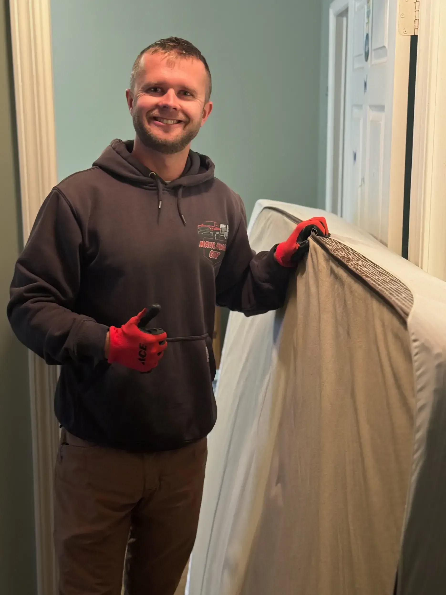 Person carrying a mattress indoors.