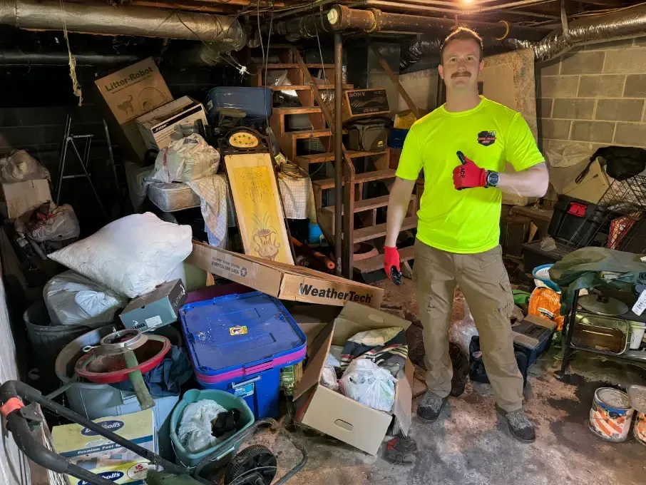 Cluttered basement with junk removal worker.