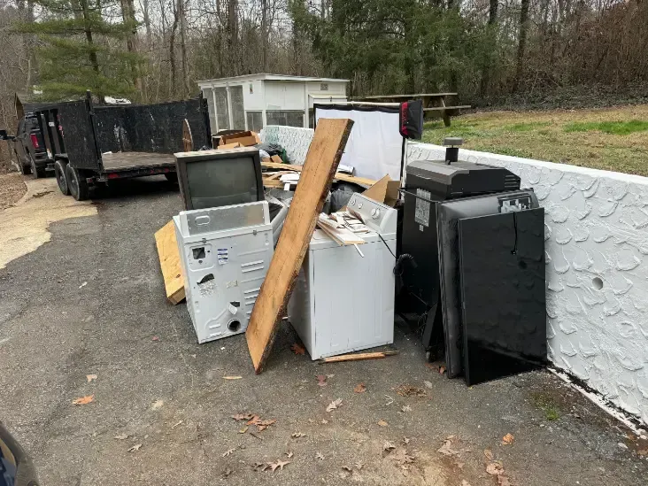 Piled appliances and debris outside.