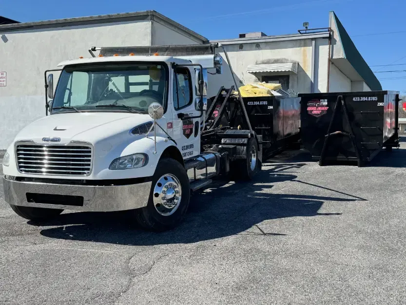 White truck with dumpster trailer